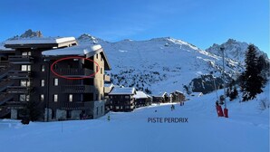 Een skigebouw met meerdere verdiepingen en een skilift op de achtergrond.