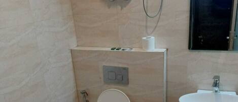 A small bathroom with a toilet, sink, and a mirror.