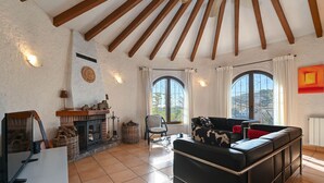 A cozy living room with a fireplace, a sofa, and a television. - Villa Las Brisas Benissa Costa (Benissa)