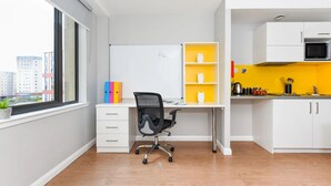 A modern apartment with a workspace, a kitchen, and a view of the city. - Student Only Merchant Studios in Glasgow (Glasgow)