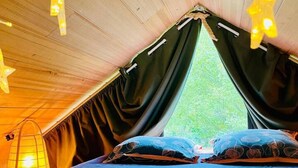 A tent with a bed, black curtains, and hanging lights. - Lodge Nid Perché - Les Cabanes de Provence (Lafare)