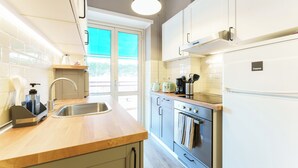 Una cocina moderna con encimera de madera, pileta de acero inoxidable y horno integrado.