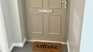 A beige door with a mailbox and a welcome mat. - 0/2 Inchcruin Apartment  - Macaulay Letting (Bonhill)