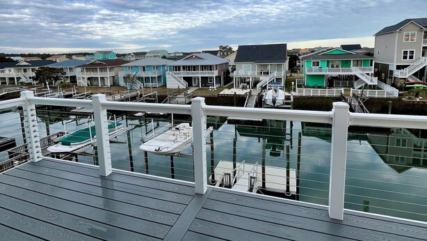 A wooden deck with a view of a marina and houses.