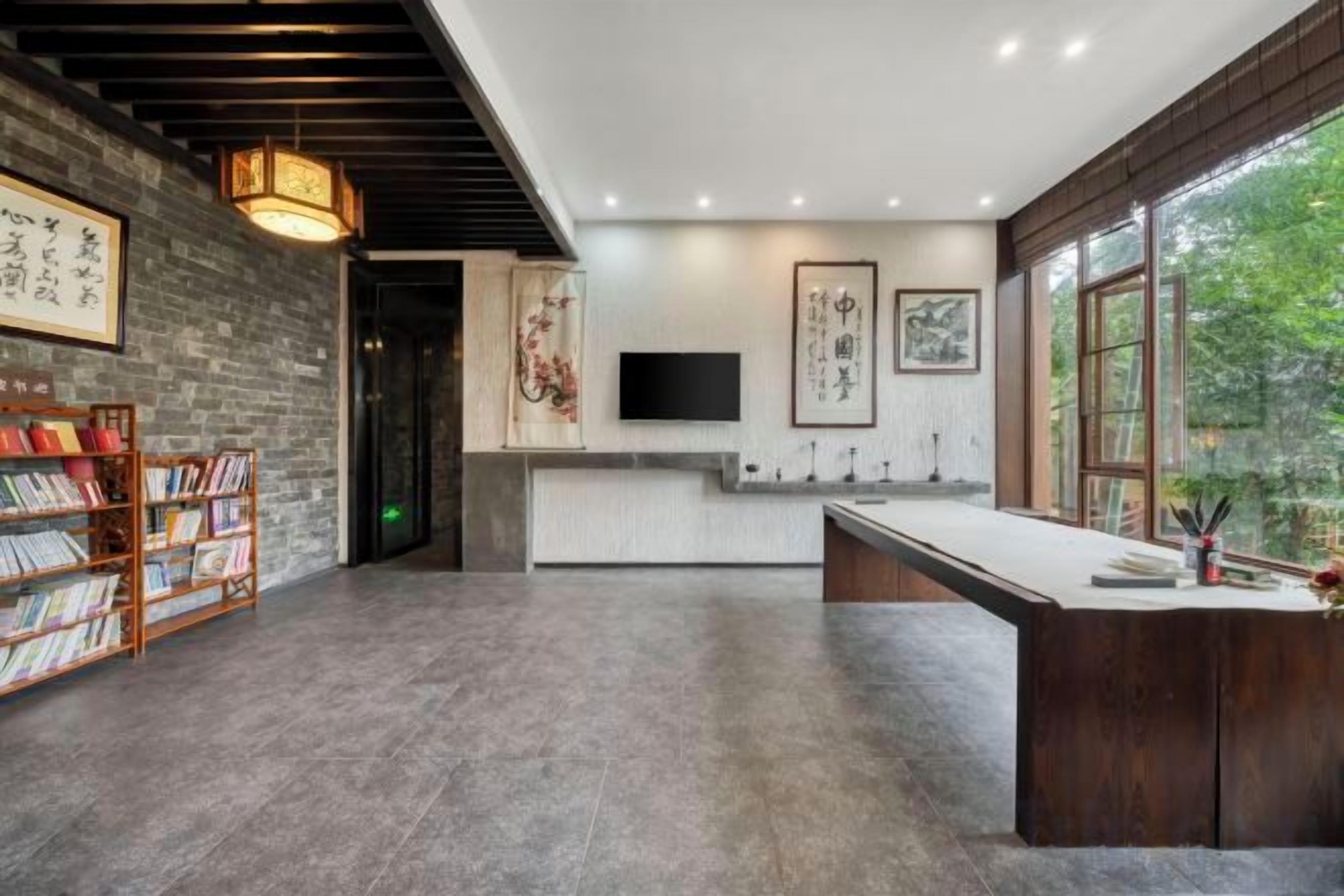 A modern interior with a kitchen area, a bookshelf, and a TV mounted on the wall.