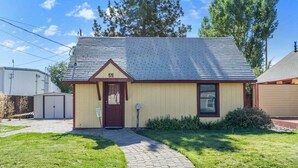 A small, single-story building with a gabled roof and a number '55' on the front. - Bluebird Day - Huckleberry Cottage in Bend, OR, perfect for a romantic getaway. (Bend)