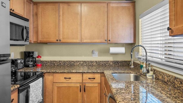 A kitchen with wooden cabinets, a granite countertop, a stainless steel sink, a microwave, and a stove. - Bluebird Day - Huckleberry Cottage in Bend, OR, perfect for a romantic getaway. (Bend)