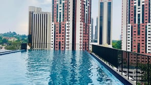 A modern high-rise building with a swimming pool in the foreground.