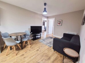 A living room with a TV, two chairs, a sofa, and a small table. - Three bedroom flat in Gloucester road north with parking (Bristol)