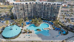 A high-rise hotel with multiple balconies, a central swimming pool, and a smaller pool area. - Edgewater Beach Front T3 Sleeps 4 book with us now! (Panama City Beach)