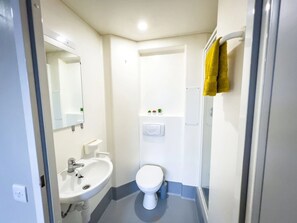Une petite salle de bain comprenant un lavabo, des toilettes et un miroir.
