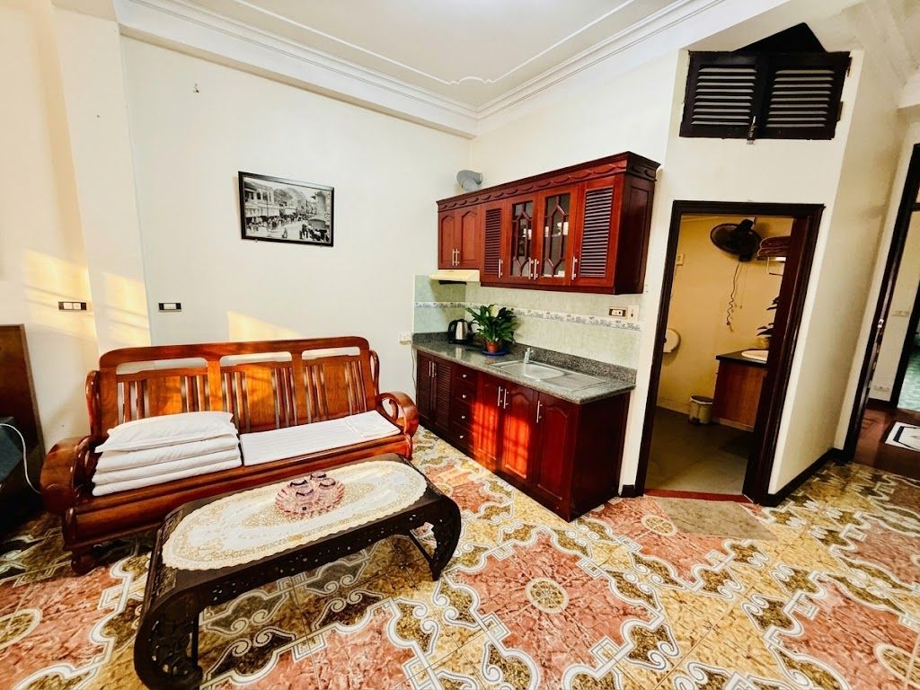 Una habitación con sofá, mesa de centro, armario y alfombra estampada.
