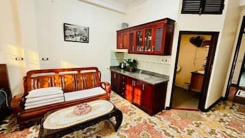Quarto com sofá, mesa de centro, armário e tapete estampado.