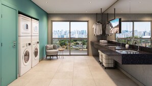 Eine moderne Küche mit Blick auf die Stadt, inklusive Waschmaschine, Stuhl und Spüle.