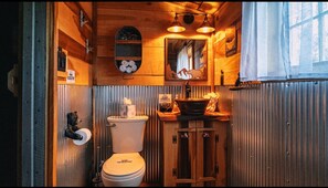 A rustic wooden bathroom with a toilet, sink, and wooden cabinets. - Mountian “Silo-tude” (Sevierville)