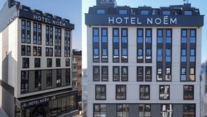 Un moderno edificio de hotel con el nombre "HOTEL NOËM" exhibido prominentemente en la fachada.