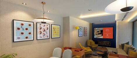 A modern living room with a sofa set, a coffee table, and framed artwork on the wall.