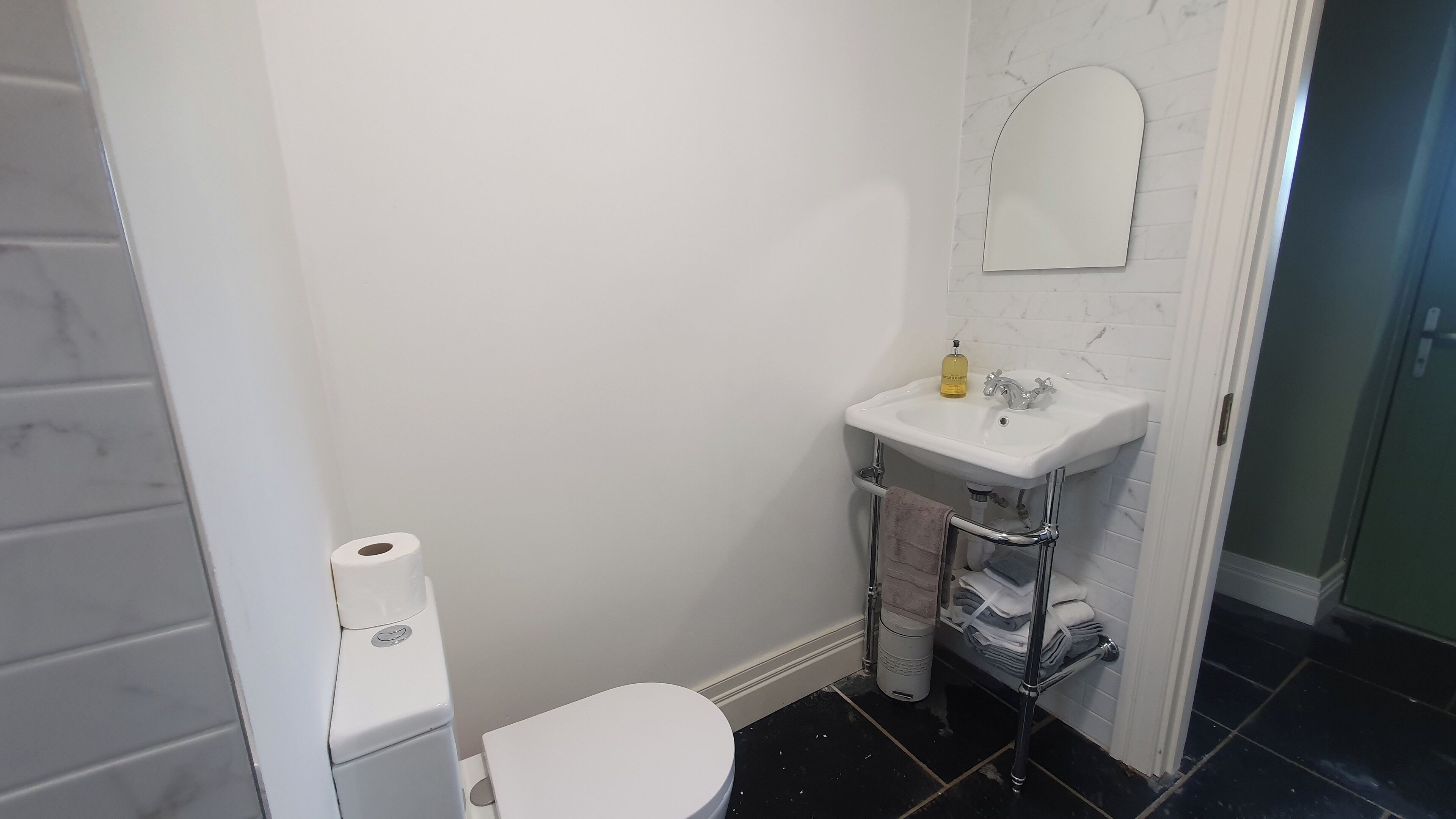 Une salle de bain avec des toilettes, un lavabo et un miroir.