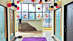 A hotel lobby with a purple carpet, a staircase, and a reception desk. - Hotel Datia Comfort Inn (Datia)