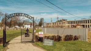 A gated entrance with a sign reading "Welter's Folly" and a metal barrel labeled "TARTER" near the gate.