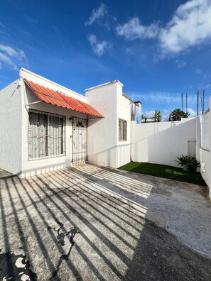 Enjoy a shaded outdoor space with a covered patio and lush green surroundings.