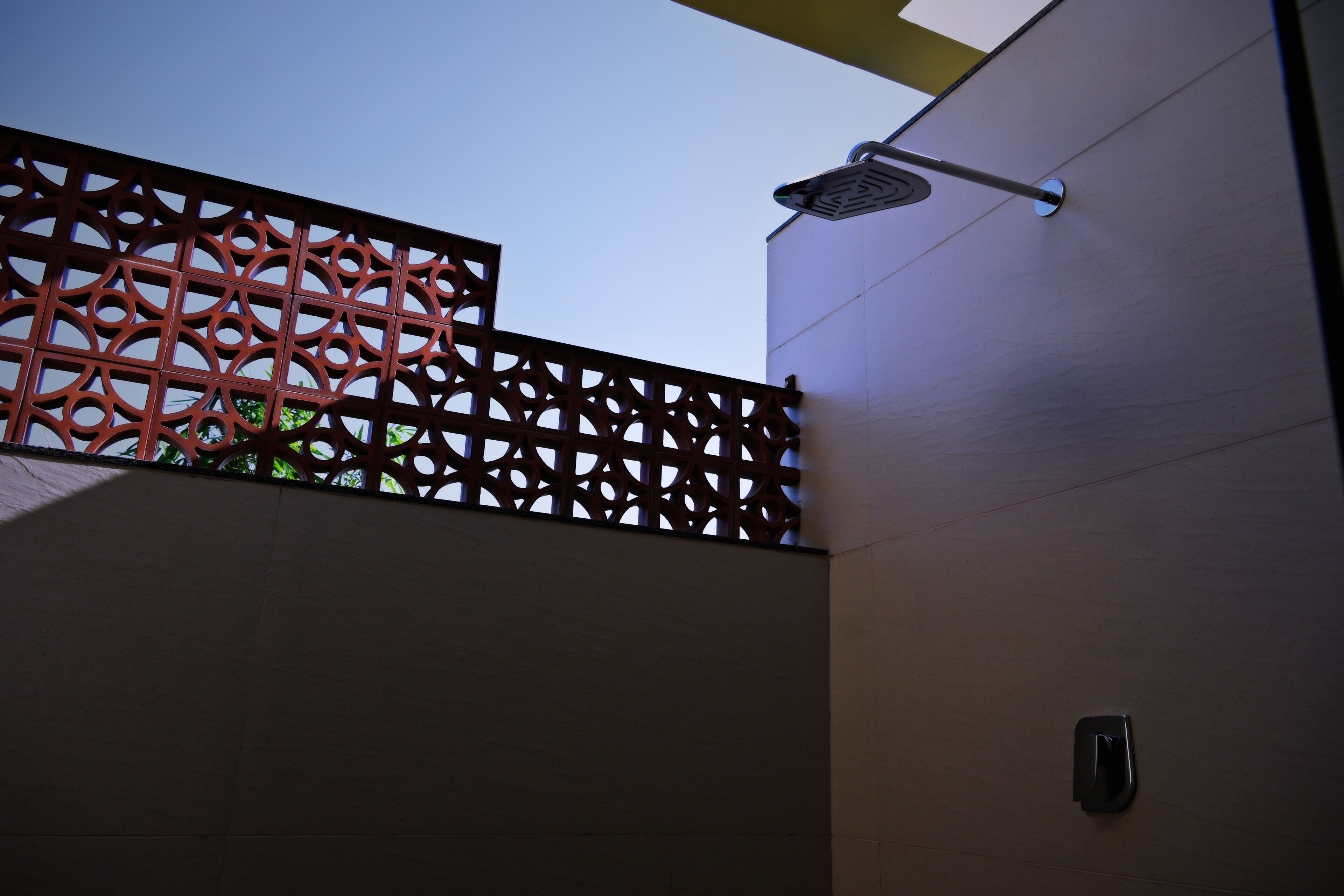 A modern building with a geometric metal fence and a flat roof.