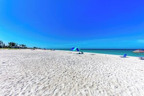 Una playa con una tienda de campaña y sillas de playa.