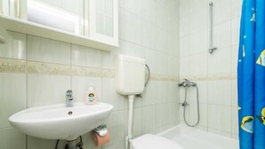 A bathroom with a sink, toilet, and shower.