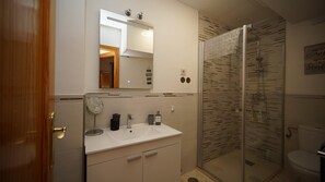 Appartement | Badkamer | Een douche, een haardroger, handdoeken