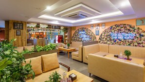 A cozy cafe with wooden accents, a bar area, and floral wall decorations. - Hotel Nova Nook (Kathmandu)