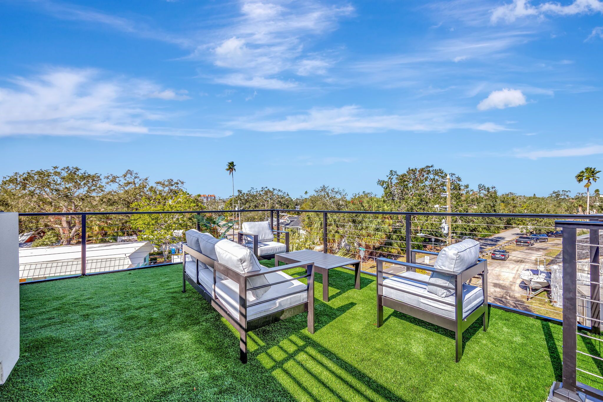 A rooftop terrace with outdoor furniture and a view of the surrounding area.