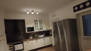 A modern kitchen with white cabinets, stainless steel appliances, and a wooden countertop. - 11rum&kök  (Sandviken)