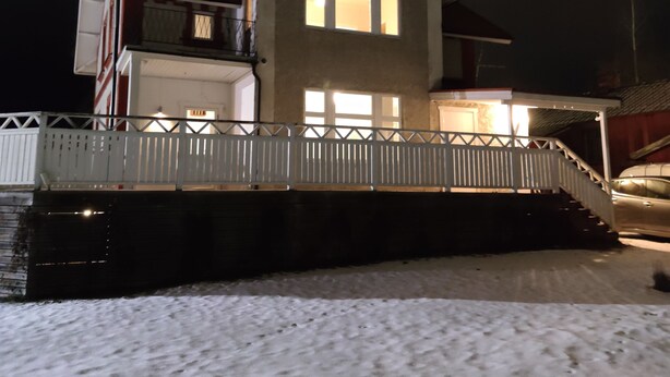 A two-story house with a balcony, a covered porch, and a snow-covered ground. - 11rum&kök  (Sandviken)