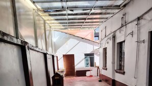 A corridor with a metal roof, concrete floor, and white walls. - Enjoyable house with shared bathroom WiFi  in charming Huancayo (Huancayo)