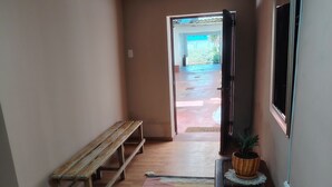 A hallway with a wooden bench, a patterned rug, and a potted plant. - Enjoyable house with shared bathroom WiFi  in charming Huancayo (Huancayo)