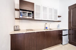 A modern kitchen with a built-in microwave, a toaster, and a stainless steel dishwasher.