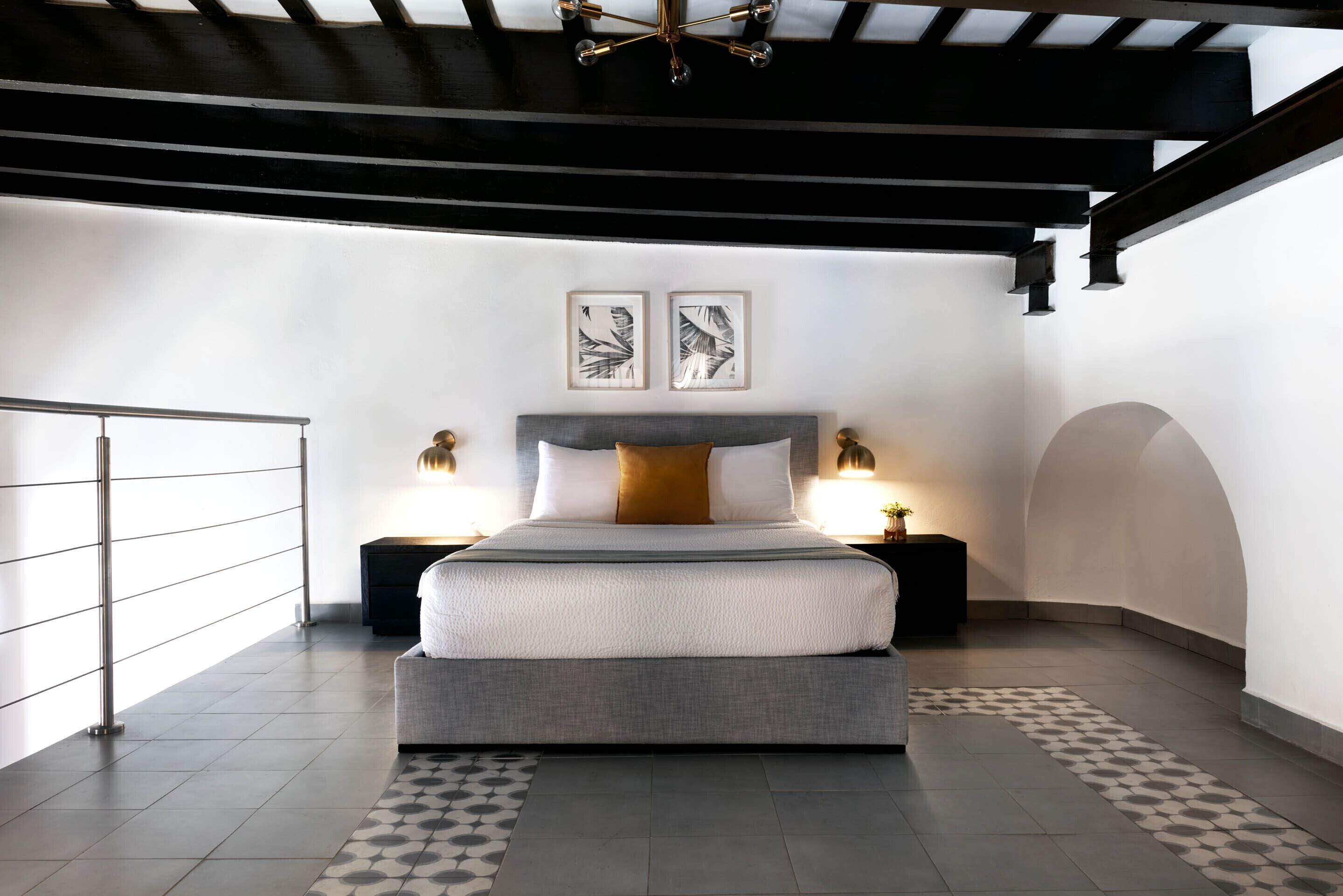 Ein modernes Schlafzimmer mit einem großen Bett, zwei Nachttischen und einer Deckenleuchte.