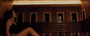 A person sitting on a wooden bench inside a room with a sloped ceiling and small windows. - Casa Las Ruinas Boutique Hotel (San Juan)