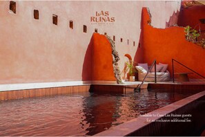 A pool area with a bench and a ladder, surrounded by walls with a unique texture and color. - Casa Las Ruinas Boutique Hotel (San Juan)