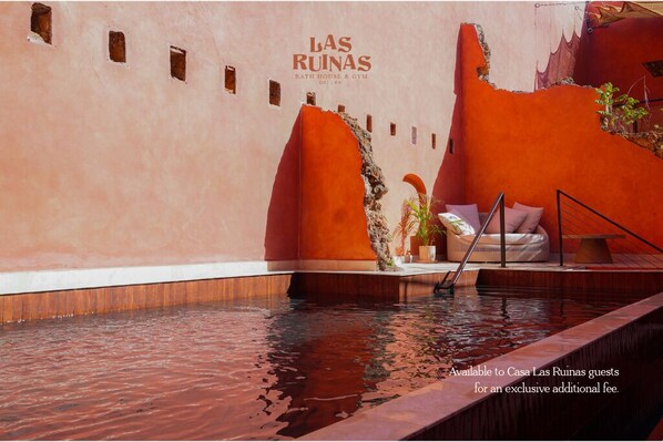 A pool area with a bench and a ladder, surrounded by walls with a unique texture and color. - Casa Las Ruinas Boutique Hotel (San Juan)