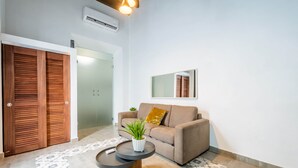 Un salon moderne avec un canapé, une table basse et une plante en pot.
