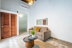 Una sala de estar moderna con un sofá, una mesa de centro y una planta en maceta.