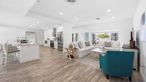 A spacious living area with a kitchen, a dining table, and a sofa. - Heated Pool · Private Fire Pit · 3 Min to Beach -Manasota Key Gem 3/3 Home (Englewood)