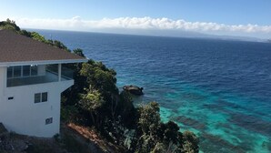 A coastal view with a house overlooking the ocean.