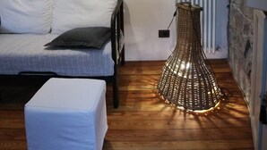 A bedroom with a bed, a bedside table, a lamp, and a radiator.