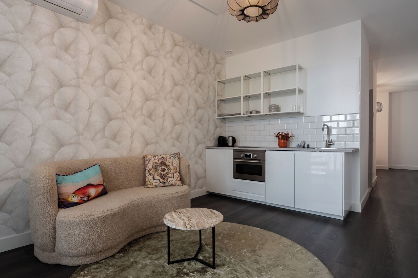 A modern kitchen with white cabinetry, a built-in oven, and a coffee maker.