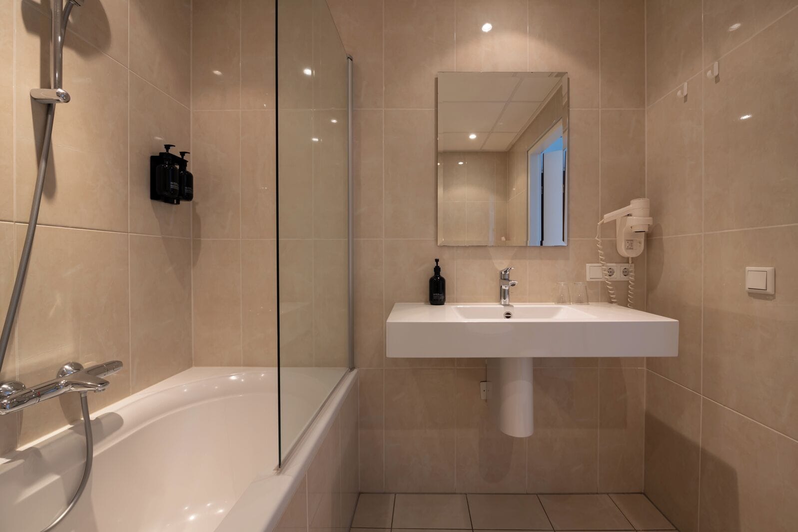 Ein modernes Badezimmer mit Badewanne, Waschbecken und Dusche.