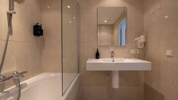 Ein modernes Badezimmer mit Badewanne, Waschbecken und Dusche.