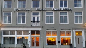 Un immeuble à plusieurs étages, avec une enseigne indiquant « Boutique Hotel Maldegem » au-dessus de l’entrée.
