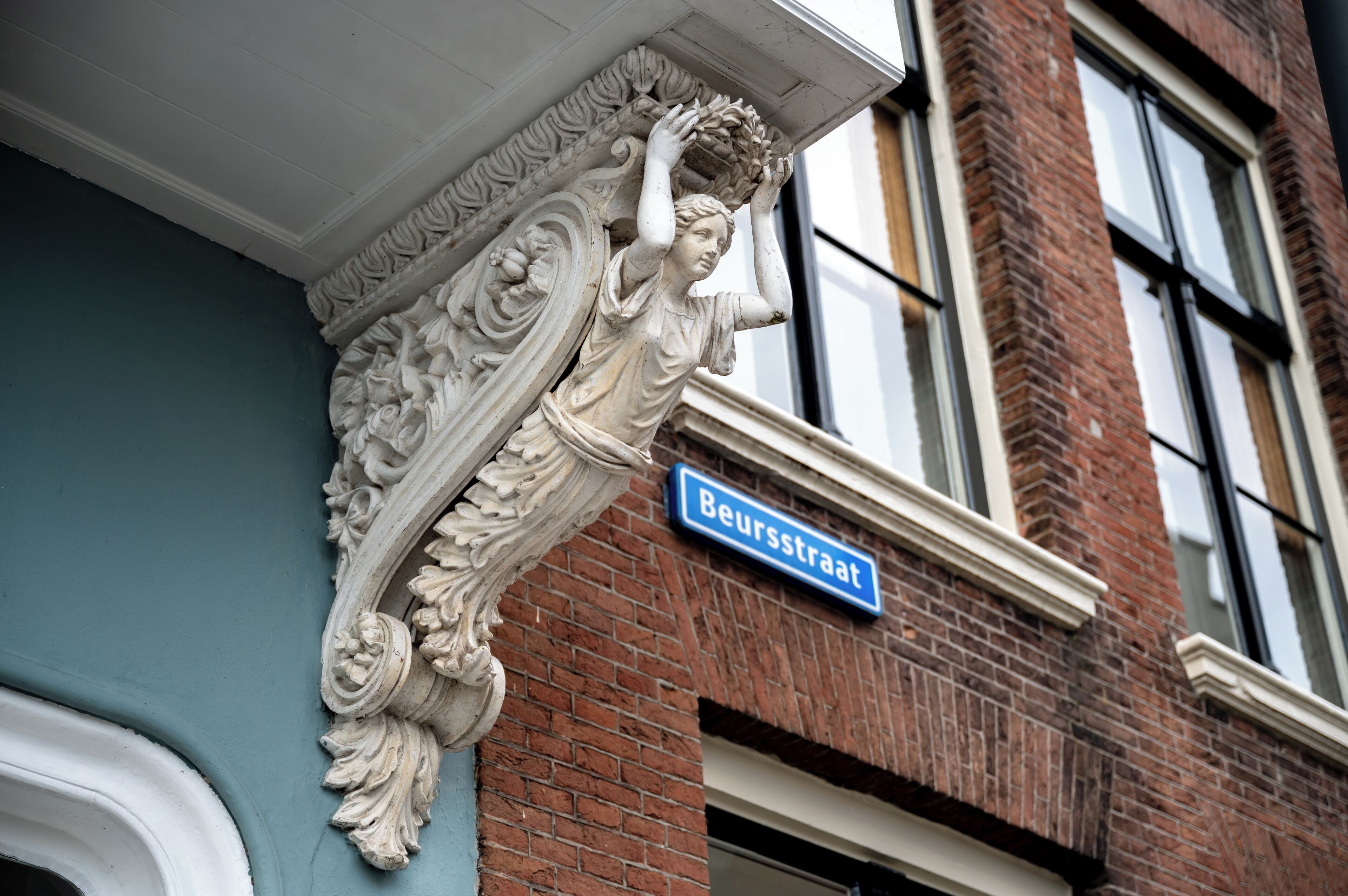 A building corner with a street sign reading "Beursstraat" and an ornate architectural detail.